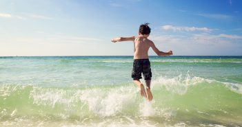 Young boy playing in ocean waves.