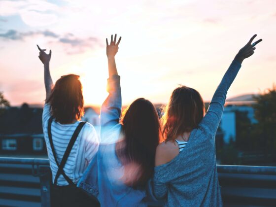 A group of women traveling together watch the sunset.